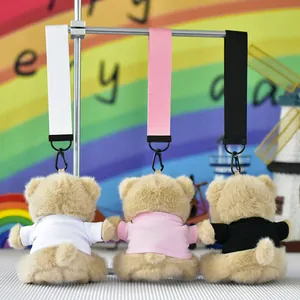 Back view of three plush teddy bear keychains wearing white, pink, and black t-shirts