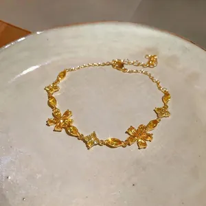 Close-up detail of a French style gold bracelet featuring sparkling yellow zircon flower charms