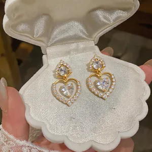 Macro detail view of luxury 18k gold plated heart earrings with sparkling CZ stones.