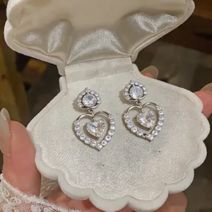 Detailed view of luxury silver 18k gold plated zircon heart shaped earrings in shell box