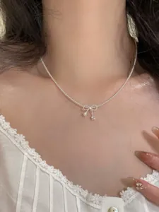 Exquisite Detailansicht einer eleganten Schleifen-Perlenkette mit Kristallanhänger am Modell