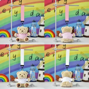 Detailed view of cute plush teddy bear keychains in pink and white outfits for gifts.