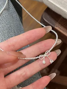 Detailansicht der zarten Schleifen-Perlenkette mit glänzendem Kristallanhänger.