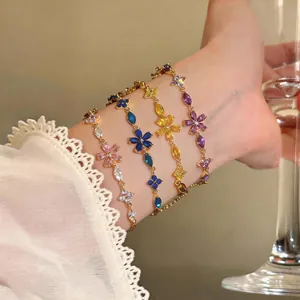 Detailed view of four colorful zircon flower bracelets worn on an elegant wrist.