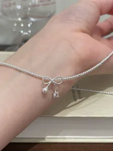 Detaillierte Ansicht einer eleganten silbernen Schleifenkette mit Perlen und Kristallen