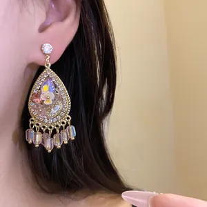 Close-up van elegante bohemian druppeloorbellen met kristallen en franje kwastjes