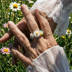 Vista dettagliata di un anello di perline a margherita su una mano in un giardino fiorito