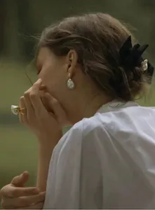 Primo piano di modella con orecchini e anello di perle barocche in stile vacanza