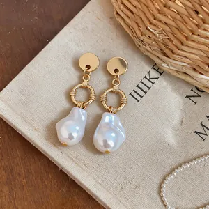 Detailed macro view of French vintage Baroque irregular pearl drop earrings in gold.