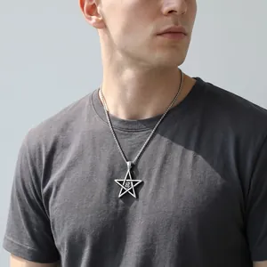 Detailed view of a silver pentagram pendant necklace for men worn on a casual grey t-shirt