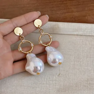 Detailed view of French Baroque irregular pearl drop earrings with gold zircon accents