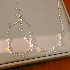 Close-up of colorful zircon round stones on a delicate silver clavicle chain.
