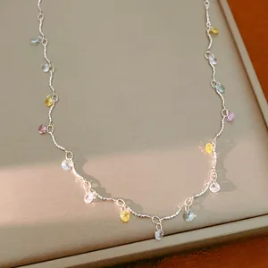 Close-up of a silver necklace featuring vibrant multi-colored round cubic zirconia charms