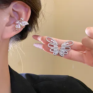 Detail view of exquisite silver butterfly wing ear clips decorated with cubic zirconia