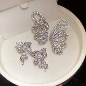 Detailed view of sparkling zircon butterfly wing ear cuffs in a white velvet jewelry box