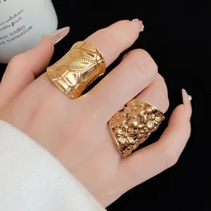 Close-up view of elegant gold-plated rings featuring quilted texture and hollow flower designs