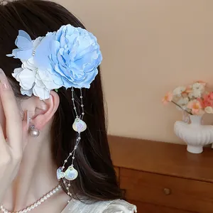 Vista dettagliata di un'elegante fermaglio per capelli a fiore in tessuto blu con nappa a conchiglia