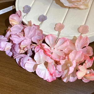 Primo piano di eleganti orecchini a nappa con fiori di resina e tessuto decorati con perle