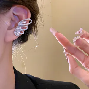 Detail view of a sparkling zircon butterfly wing ear cuff worn on a female model's ear