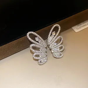 Macro detail of elegant zircon butterfly wing ear clips with shimmering stones inlay