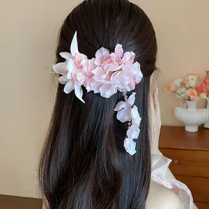 Elegante fermaglio per capelli a fiore in tessuto rosa con nappa a petalo su modella