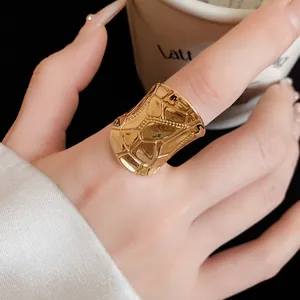 Macro detail of a wide gold textured ring with geometric pattern for a luxury look