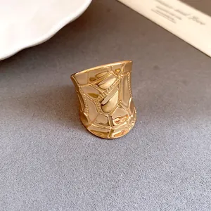 Detail shot of a wide gold statement ring featuring unique geometric cracked patterns