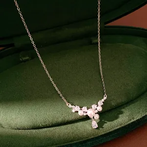 Detail shot of elegant silver pearl necklace with zircon teardrop in green velvet box