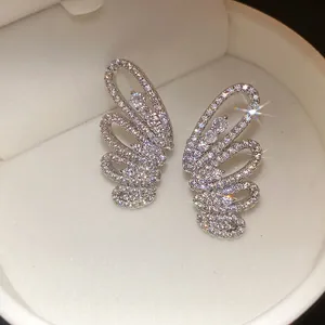Close-up of sparkling zircon butterfly wing ear clips presented in a luxury white box