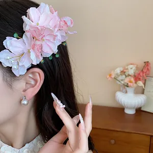 Dettaglio di un fermaglio per capelli in tessuto rosa con perle e perline stile fata