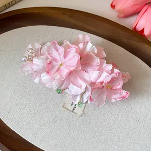 Dettaglio ravvicinato di un'elegante molletta a fiore in tessuto rosa con perle e perline