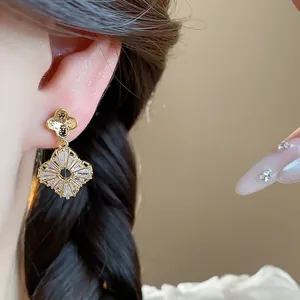 Primo piano di elegante orecchino a fiore in oro con dettagli in zircone scintillante
