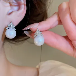 Detailed view of elegant pearl stud earrings with sparkling zircon geometric design