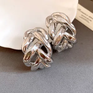 Close-up detail showing the metallic texture of chunky silver-toned chain-link C-shaped earrings