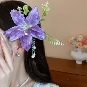 Elegante fermaglio per capelli in tessuto viola con nappe d'argento e foglie verdi su modella