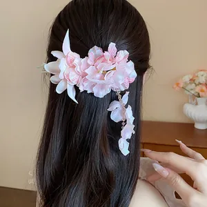 Primo piano di un'elegante clip per capelli a fiore in tessuto rosa con petali cadenti