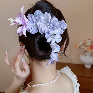 Elegante fermaglio per capelli con fiori in tessuto viola e blu su uno chignon stile cinese