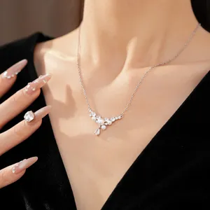 Detailed view of an elegant silver necklace with water-drop zircon and pearls on a model