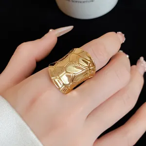 Detailed close-up of a chunky gold-plated ring featuring a geometric hammered texture