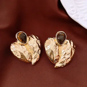 Detailed view of vintage gold hammered leaf earrings with teardrop tiger eye gemstones