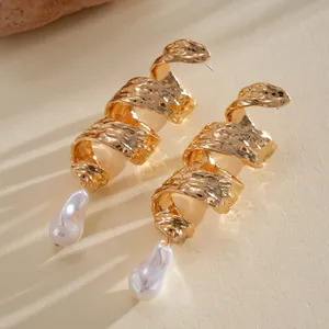 Close-up of vintage gold spiral earrings with irregular baroque pearl pendants