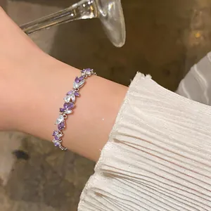 Vue détaillée d'un bracelet élégant avec des zircons violets et blancs portés au poignet