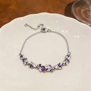 Gros plan détaillé d'un bracelet géométrique en zircon violet et blanc sur une assiette blanche