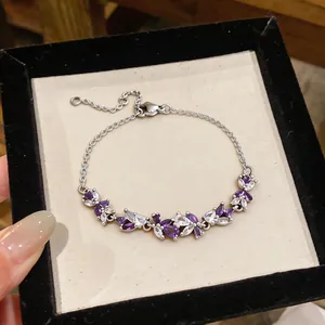 Détail rapproché d'un bracelet en argent orné de zircons violets et clairs en goutte d'eau.