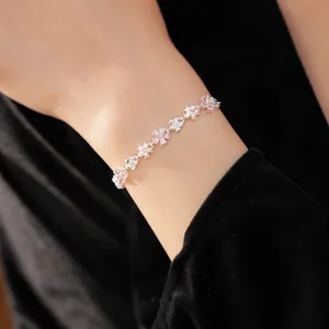 Gros plan d'un bracelet de fleurs en zircon et perles sur le poignet de mannequin