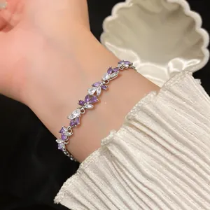 Gros plan détaillé d'un élégant bracelet en zircone violet et blanc en forme de goutte.