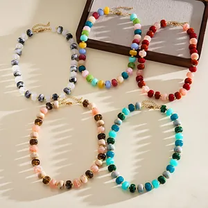 Detailed view of five colorful marbled acrylic bead necklaces in dopamine style.