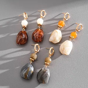 Detail of retro irregular geometric resin earrings with marble texture in various colors.