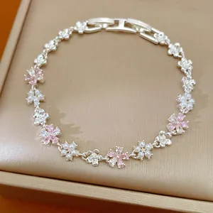 Vue macro détaillée montrant les élégantes fleurs en zircon et perles sur un bracelet argenté