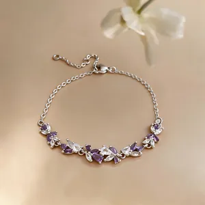 Gros plan d'un bracelet en argent élégant avec des pierres de zircon violettes et blanches.